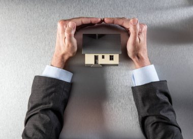 güvenli yalıtım korumak ve çatı güvenliğini sağlama işadamı elleri ile ev