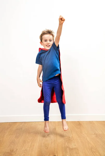 Emocionado hermoso niño vestido como un poderoso superhéroe saltando — Foto de Stock