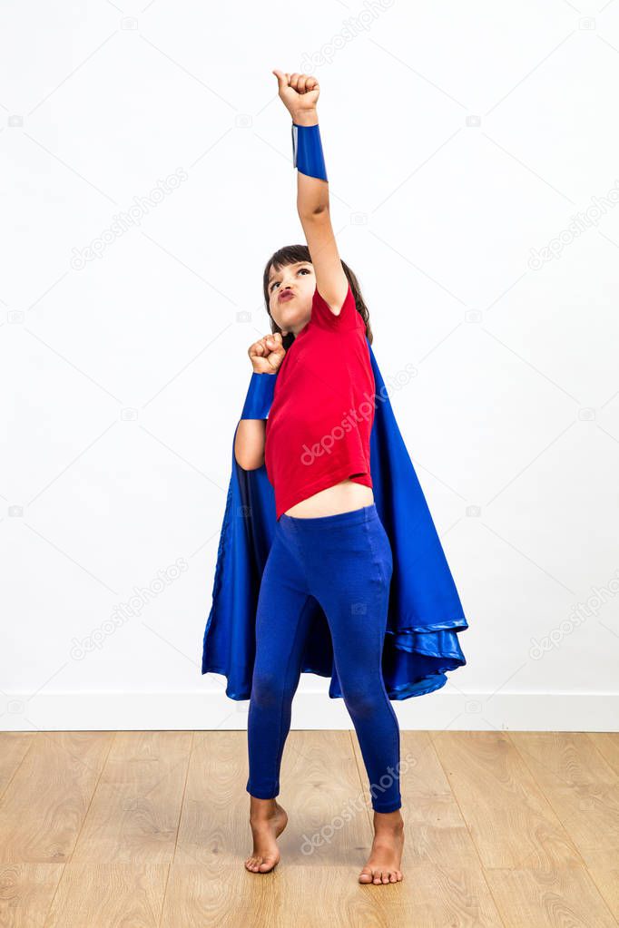 Winning super hero child playing with a powerful arm raised