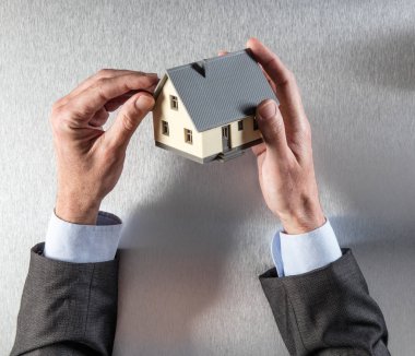 işadamı eller ev değerleme veya izolasyon çatı bakarak 