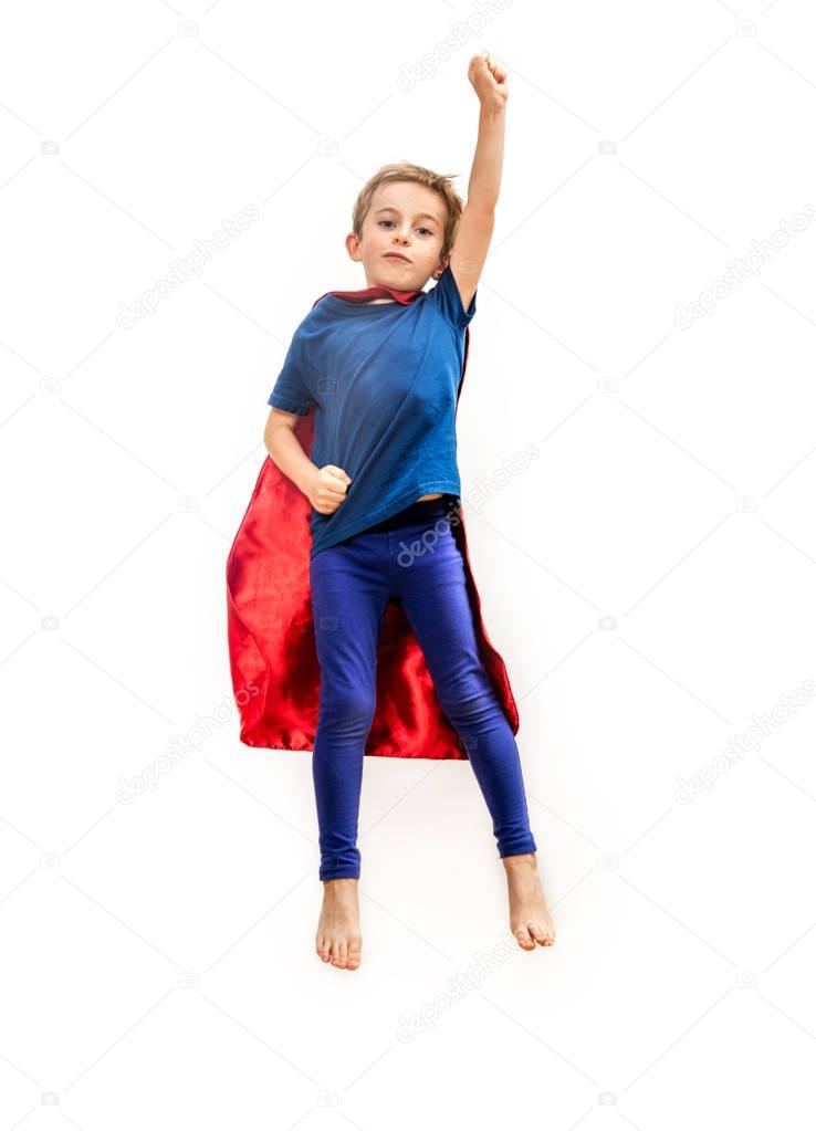 Isolated superhero boy with cape pretending gripping freedom over white