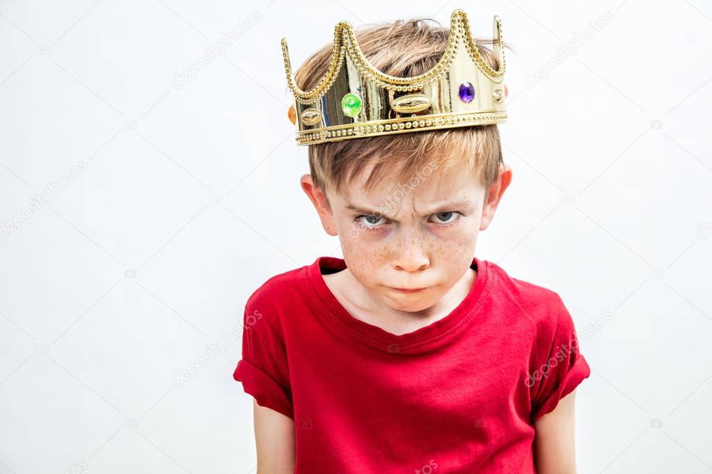irritated beautiful spoiled boy with dirty look and golden crown