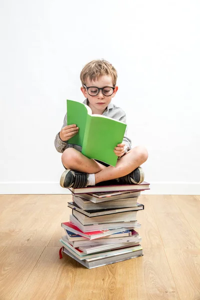 Επικεντρώθηκε αγόρι ανάγνωση πολλών βιβλίων για το smart Δημοτικό σχολείο, σε εσωτερικούς χώρους — Φωτογραφία Αρχείου