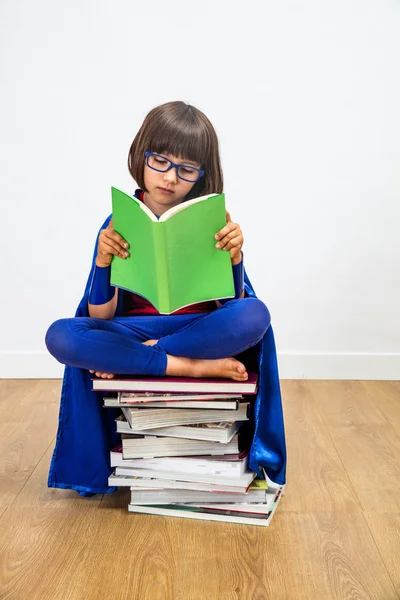 Superhéroe chica leyendo libros para estudiar el poder y la imaginación femenina —  Fotos de Stock