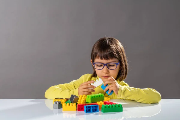 Koncentrált fiatal gyermek játszó építőelemeket és karrier mérnök — Stock Fotó