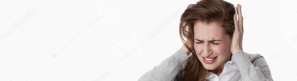 sick young woman at tinnitus or listening to loud music