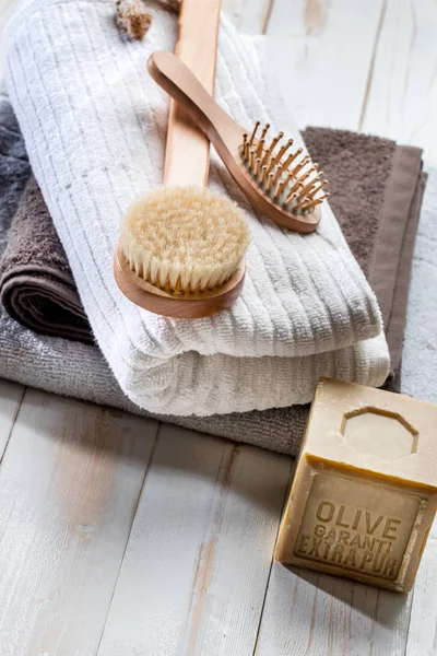 Solid soap, body brush, hairbrush and towels for green bath — Stock Photo, Image
