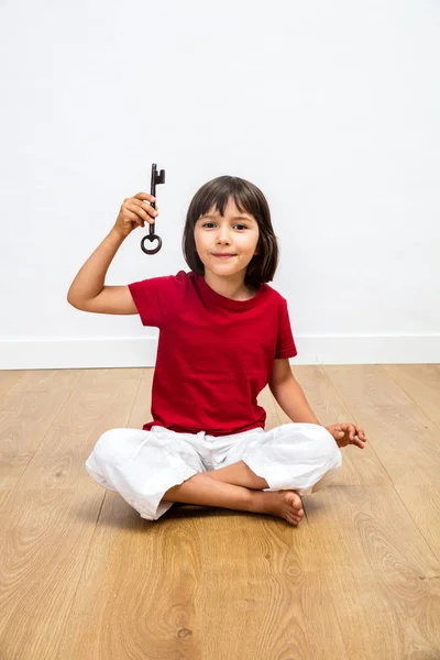 Menina sorrindo segurando chave para a motivação, otimismo e educação — Fotografia de Stock