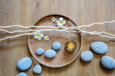 kavramı doğal kadın akışı ve ritim ayurveda spa dekor ile güzel çakıl, mum, taze çiçekler ve dal üzerinde görünümünün üzerinde ahşap tepsi yuvarlak oluşur
