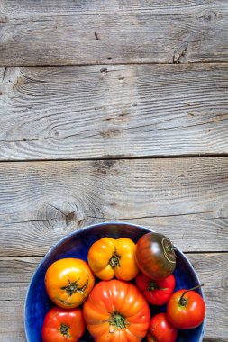 yarıya tabak rustik domates ile sürdürülebilir yaz yemek organik vejetaryen menü için vintage ahşap arka plan üzerinde renkli, dikey üstten görünüm kopyalama alanı sınırı