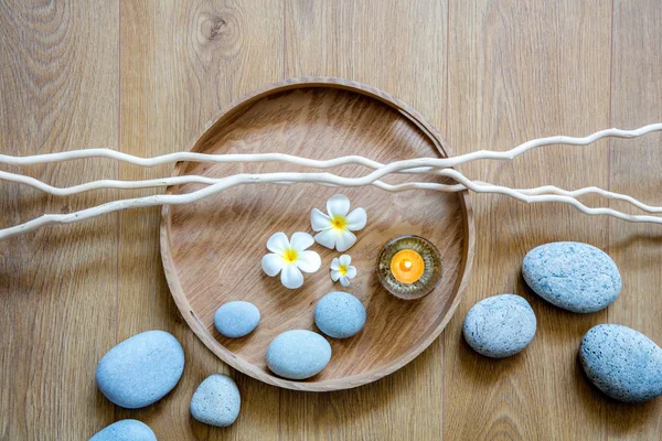 Zen akışı çakıl taşları, mum, çiçek ve dallar üzerinde ahşap