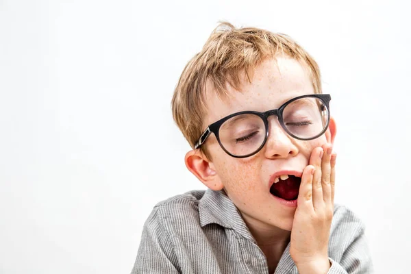 Портрет зевающего мальчика без зуба и очков, изолированный — стоковое фото
