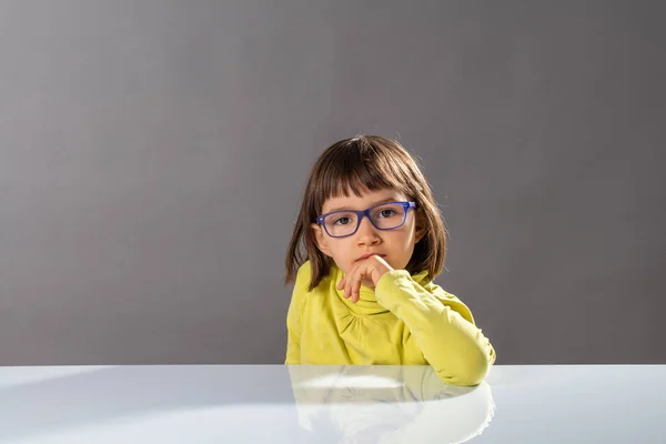 Aranyos gondolkodó gyermek szemüveges élvezi gondolkodás, belenéz kamera — Stock Fotó