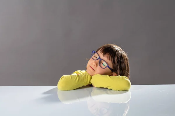 Tranquilo niño feliz durmiendo en el escritorio para meditar por la idea — Foto de Stock