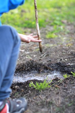 İsimsiz bir çocuk çamurla oynarken eğleniyor, gerçek hayatta.
