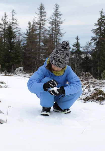 Happy winter child touching and playing with snow for snowball — 스톡 사진