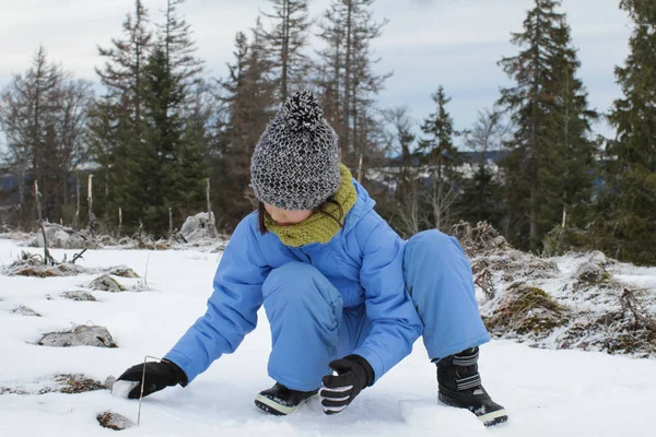 Young winter child experiencing making cold snowballs over mountain trees — 스톡 사진
