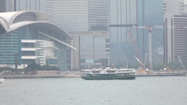 HONG KONG - DIC 23 2016: Star Ferry está navegando a través del puerto de Victoria, con el horizonte de Hong Kong como telón de fondo. Vídeo 4K — Vídeo de stock
