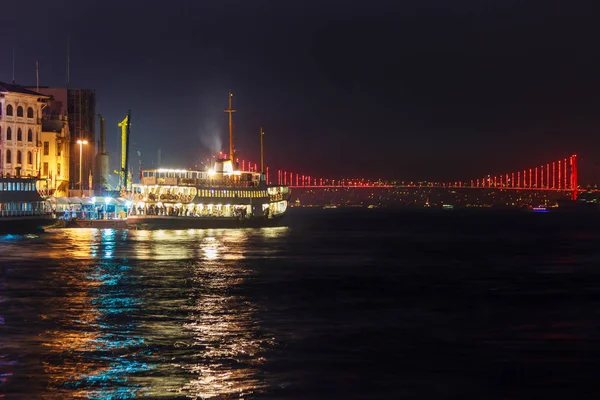 View of Galata quarter on the Bosporus and a bridge in the distance at night. Istanbul. — Stock Photo, Image