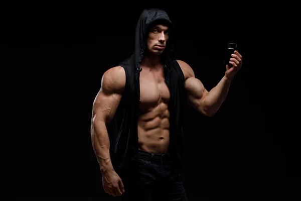 暗い背景にタンパク質の瓶と筋肉のボディビルダー スポーツ栄養 ボディビルディング栄養補助食品 スポーツ ワークアウト 健康的なライフスタイルのコンセプト — ストック写真