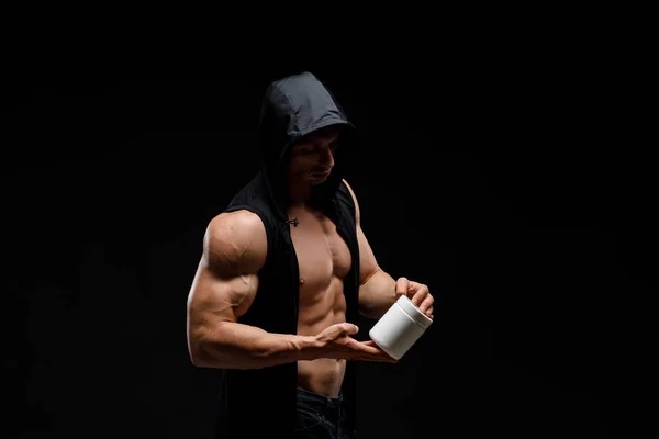 暗い背景にタンパク質の瓶と筋肉のボディビルダー スポーツ栄養 ボディビルディング栄養補助食品 スポーツ ワークアウト 健康的なライフスタイルのコンセプト — ストック写真