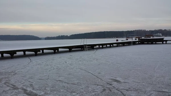 Zugefrorener See und Holzsteg an einem bewölkten Tag — Stockfoto