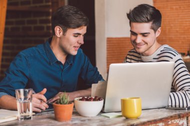 işletme sahipleri dizüstü bilgisayar kullanırken konuşuyor