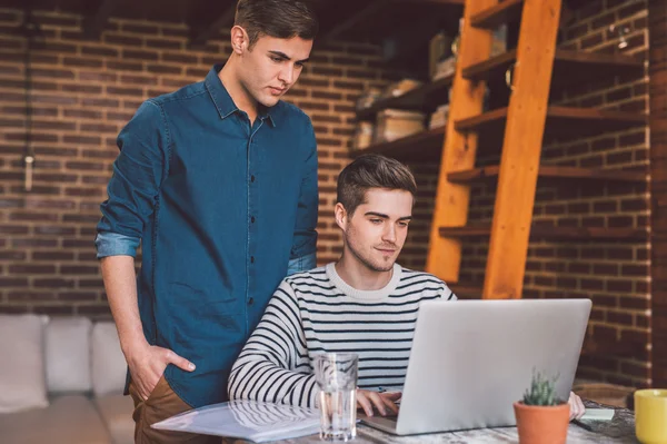 Proprietários de empresas conversando juntos ao usar laptop — Fotografia de Stock