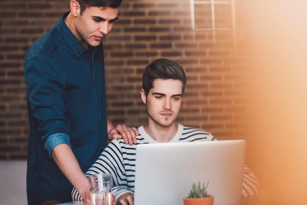 Gay couple talking while using laptop — Stock Photo, Image