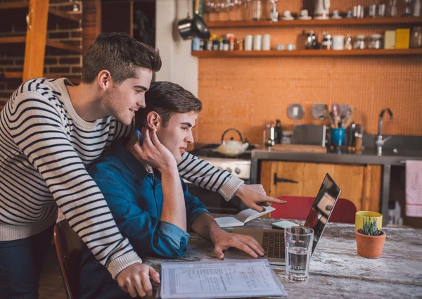 Business owners talking together while using laptop — Stock Photo, Image