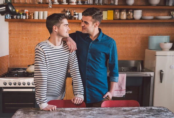 Gay couple standing side by side in kitchen — Stock Photo, Image