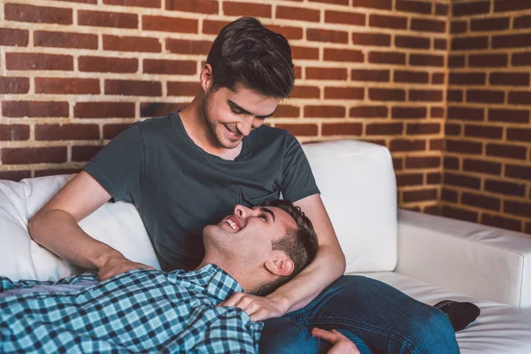 Homosexuální pár spolu na pohovce doma — Stock fotografie