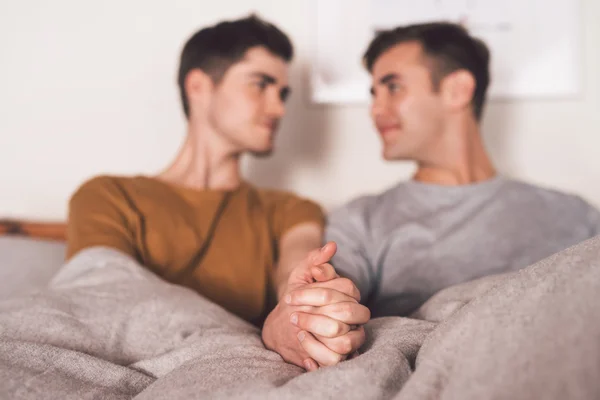 Gay couple holding hands together in bed — Stock Photo, Image