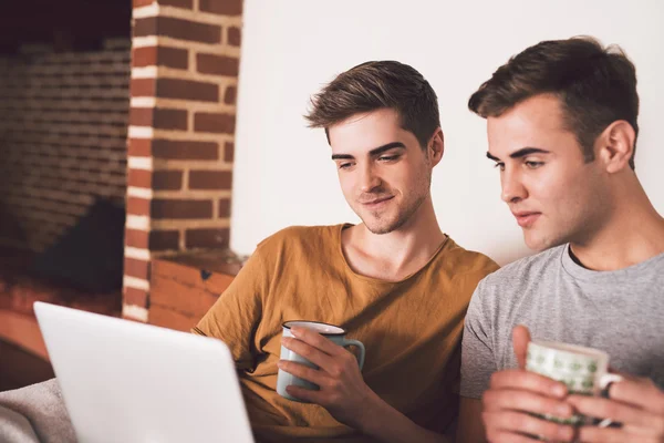 Homo paar met behulp van laptop en koffie drinken — Stockfoto