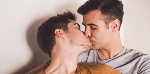 Gay couple baisers tandis que couché dans lit — Photo