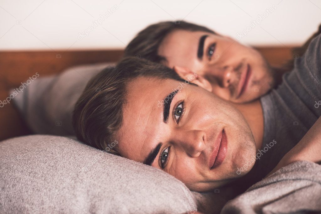 gay couple lying together in bed