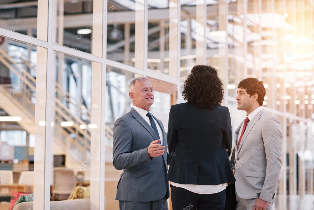 business people talking together while standing in lobby