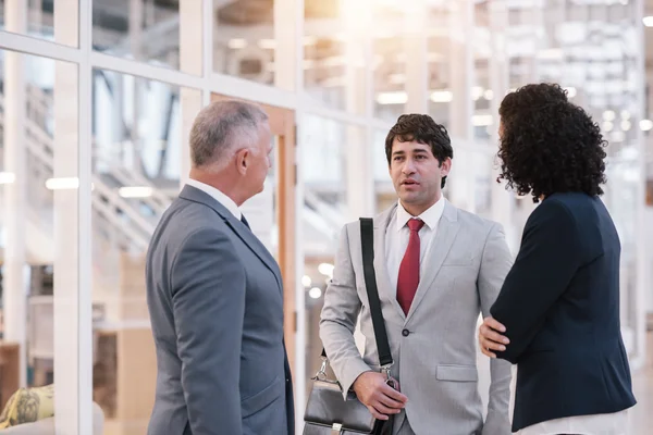 Gente de negocios hablando juntos mientras están en el vestíbulo —  Fotos de Stock