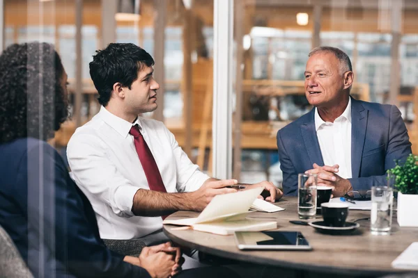 Hombre de negocios hablando con jóvenes miembros del personal — Foto de Stock