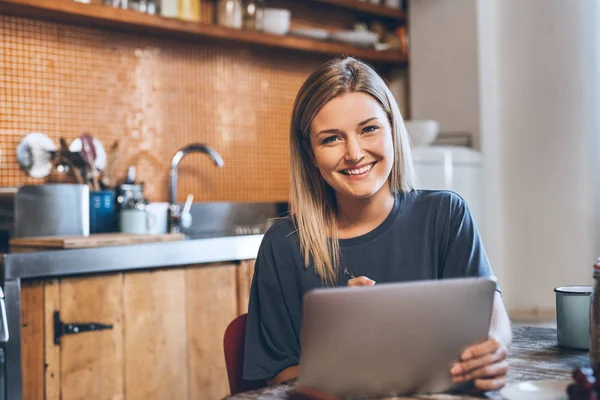 Vrouw met behulp van de tablet terwijl het eten van ontbijt — Stockfoto