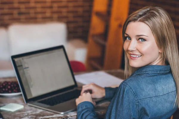 Vrouw kijken over de schouder en het gebruik van laptop — Stockfoto