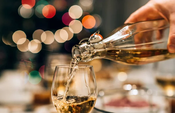 Homem derramando vinho branco em vidro — Fotografia de Stock