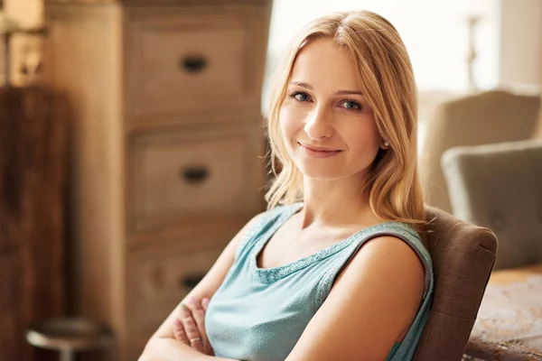 Mulher sorrindo enquanto se senta na cadeira — Fotografia de Stock