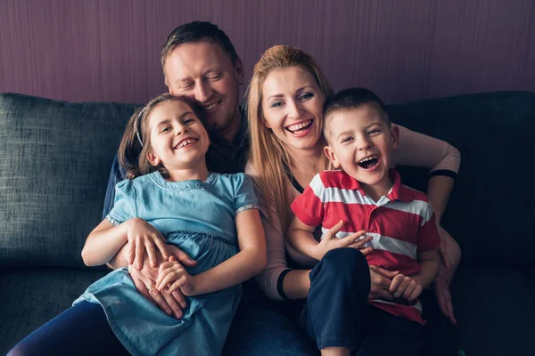 Familia feliz sentados juntos en el sofá — Foto de Stock