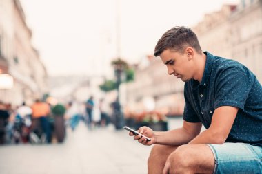 Bankta Smartphone kullanan adam