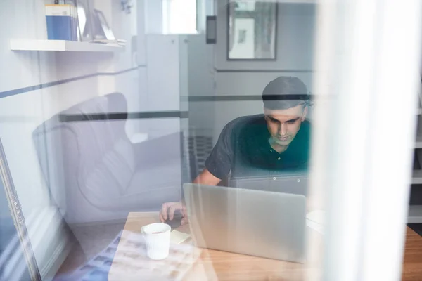 Hombre usando el ordenador portátil en casa — Foto de Stock