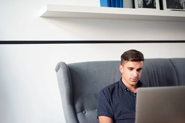 Hombre usando el ordenador portátil en sofá — Foto de Stock