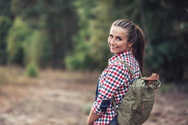 Ormanda bir yürüyüş için dışarı gülümseyen kadın