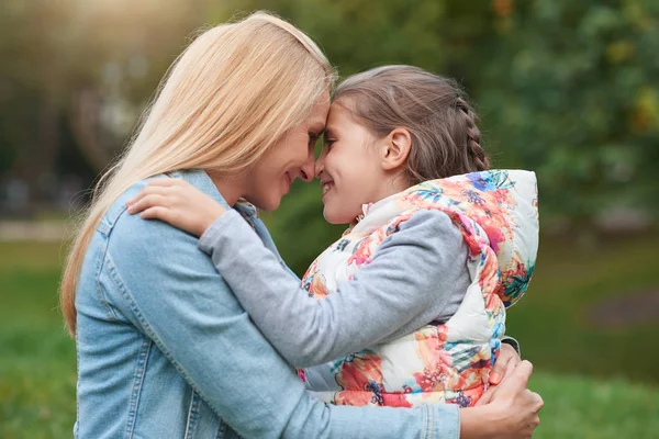 Menina abraçando mãe no parque — Fotografia de Stock