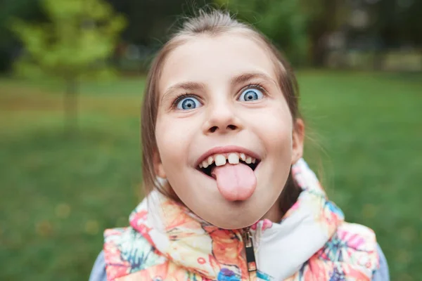 Kislány kinyújtja a nyelvét — Stock Fotó